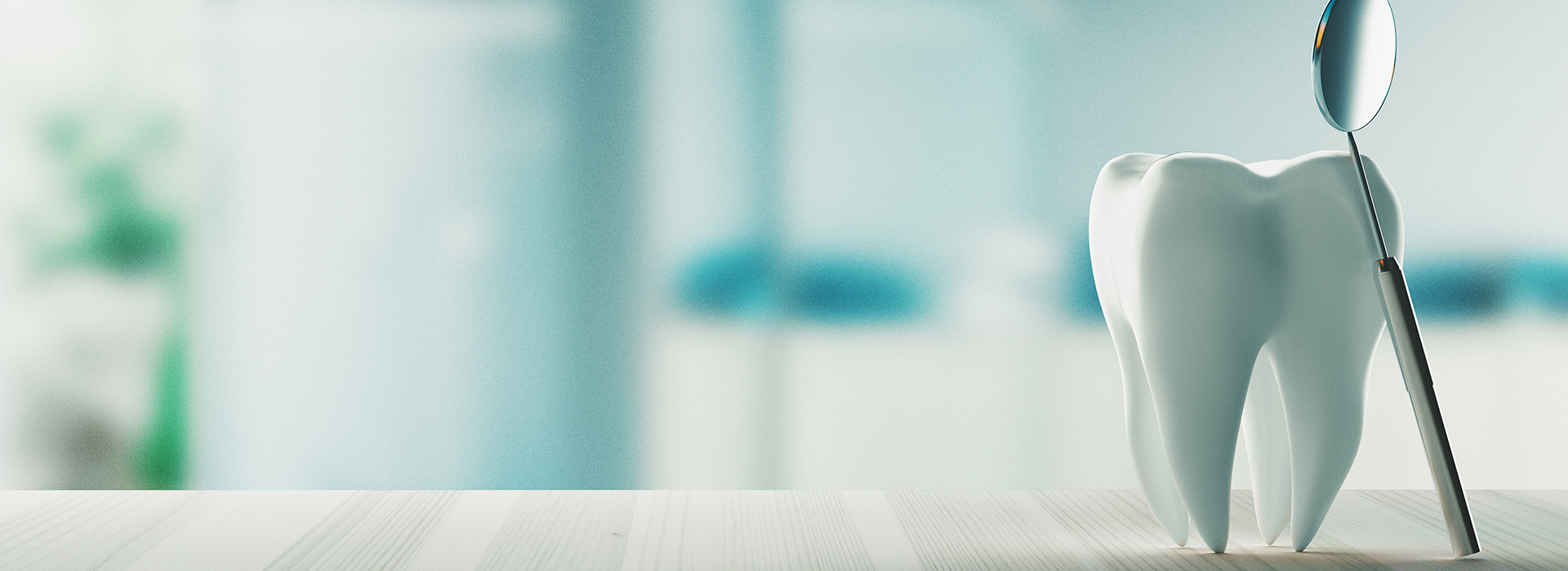 A toothbrush with a toothpaste tube on a countertop, set against a blurred background.